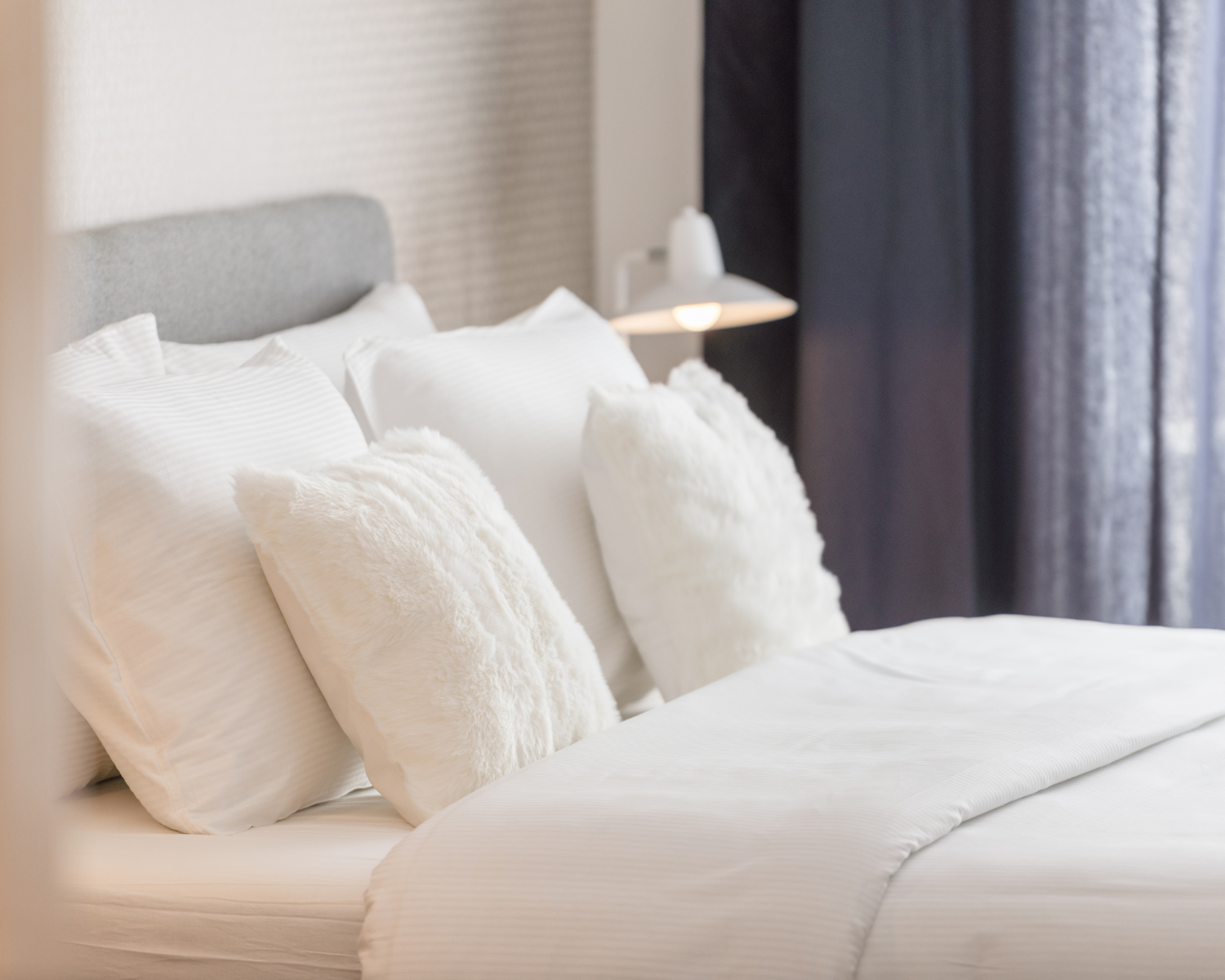 Clean, white linens on a made bed