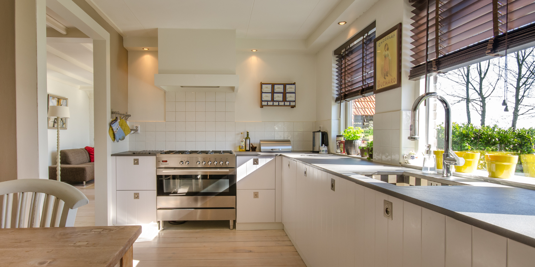 Clean & modern kitchen in Rossland, BC with stainless steel appliances and wooden dining table.